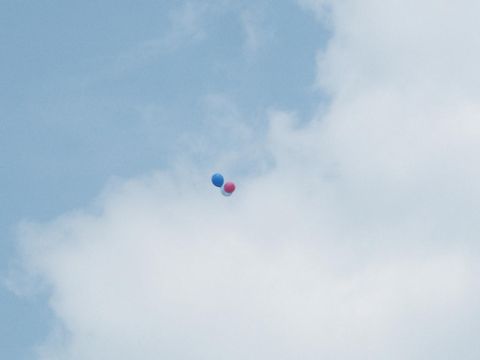 2001 Mercury Grand Marquis - A few balloons drift against a backdrop of clouds and blue sky.