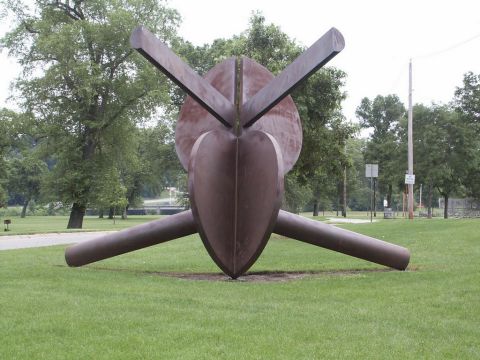 2001 Mercury Grand Marquis - An abstract metal sculpture is displayed in a grassy park area with trees in the background.