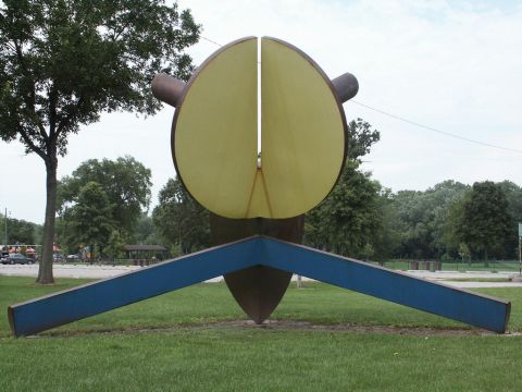 2001 Mercury Grand Marquis - An abstract sculpture stands in a park with trees and a cloudy sky in the background.