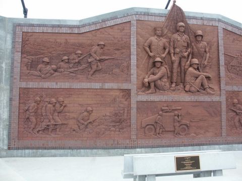 2001 Mercury Grand Marquis - A large brick mural shows scenes of soldiers in combat and a military vehicle, part of a "Cross Country Trip" section.