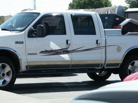 2001 Mercury Grand Marquis - White Ford F-250 Super Duty pickup truck with a tribal graphic decal on its side.