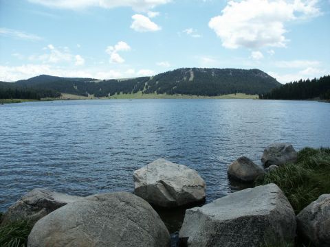 2001 Mercury Grand Marquis - A scenic view of a lake surrounded by trees and mountains, with large rocks in the foreground.