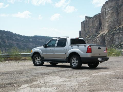 2001 Mercury Grand Marquis - A silver pickup truck is parked on a dirt road, with a scenic mountain landscape behind it.