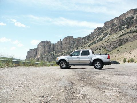 2001 Mercury Grand Marquis - Ford Explorer Sport Trac parked roadside with a scenic mountain backdrop.