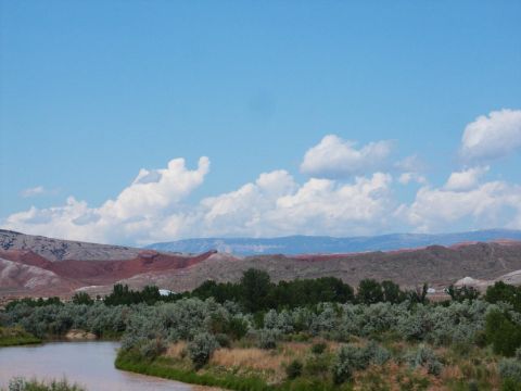2001 Mercury Grand Marquis - A scenic view of a river flowing through a valley with mountains in the background under a partly cloudy sky.