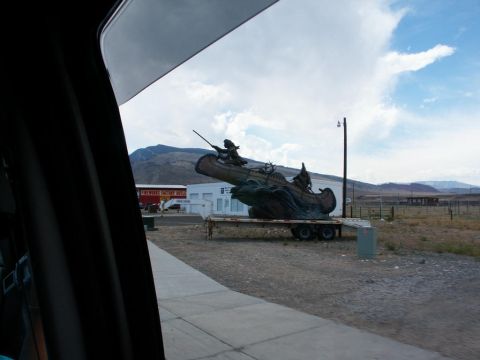2001 Mercury Grand Marquis - A large sculpture depicting people in a canoe is displayed on a trailer in an outdoor setting.