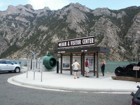 2001 Mercury Grand Marquis - A silver SUV is parked near the entrance to a dam and visitor center, with a large green turbine visible.