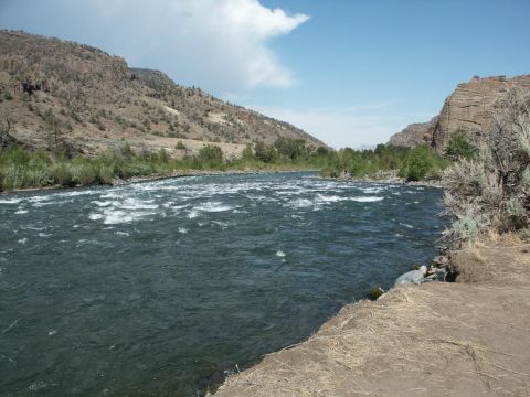 2001 Mercury Grand Marquis - A wide river rushes through a rocky canyon under a bright blue sky with scattered clouds.