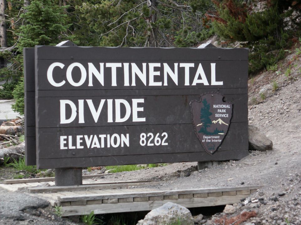 Wooden sign reading CONTINENTAL DIVIDE ELEVATION 8262 with National Park Service logo