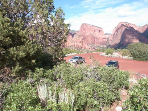 2001 Mercury Grand Marquis - Two vehicles are parked in a scenic desert area with large red rock formations under a blue sky.