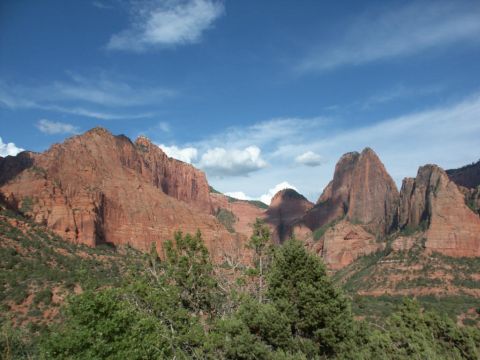 2001 Mercury Grand Marquis - A vast landscape of red rock formations and green foliage under a bright blue sky.