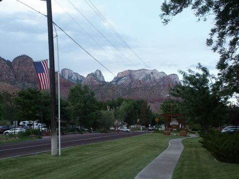 2001 Mercury Grand Marquis - Scenic view of mountains with an American flag and trees, a road and sidewalk are visible.