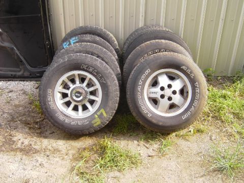 1995 Jeep YJ - Several Jeep wheels and tires are stacked up, with one set showing the 'Jeep' logo.