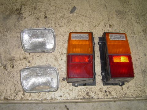 1995 Jeep YJ - A pair of rectangular headlights and two Jeep YJ taillights are displayed on a textured surface.