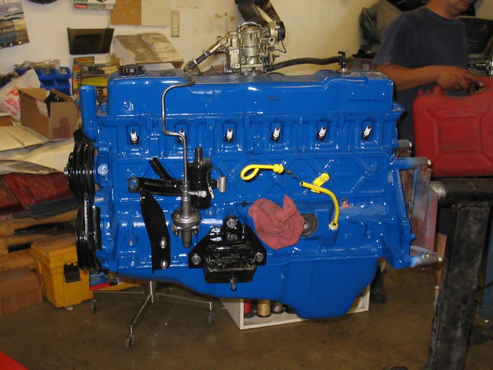 Blue engine block on stand with carburetor and red rag