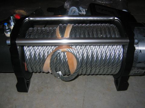 1979 Ford Bronco - A winch with a thick steel cable coiled around its drum, secured with leather straps.