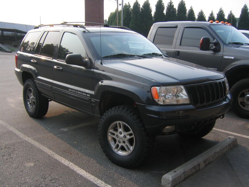 Dark Jeep Grand Cherokee 3/4 front view. "GRAND CHEROKEE" badge visible