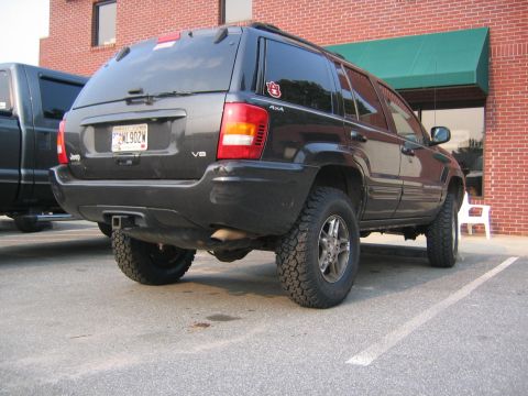 2005 Ford F-250 - Rear view of a black Jeep Grand Cherokee with aftermarket tires and a trailer hitch.
