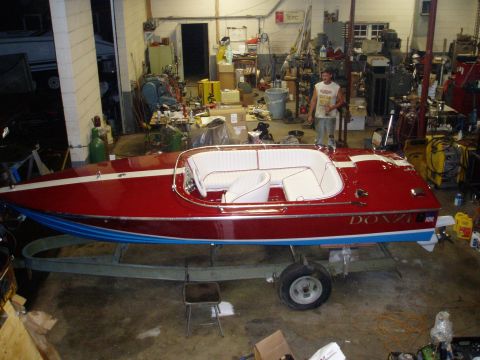 1978 Ford F-250 - A red speed boat with white upholstery sits on a trailer inside a cluttered garage.