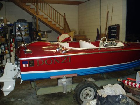 1978 Ford F-250 - A red and blue Donzi boat with white upholstery is parked on a trailer inside a garage.