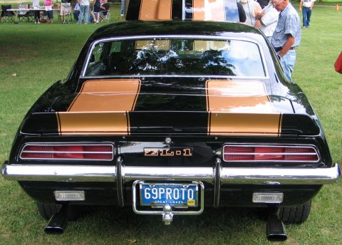 1994 Ford Bronco - The rear of a black 1969 Camaro ZL1 with gold racing stripes is shown, a custom license plate.