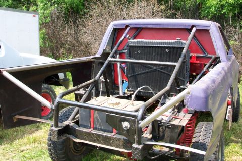 1978 Ford Bronco - This heavily modified truck features a prominent roll cage and exposed mechanical components, with another vehicle in the background.