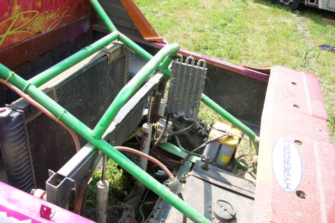 1978 Ford Bronco - Engine bay of a modified off-road vehicle, a roll cage and aftermarket parts.