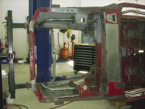 1990 Ford Mustang - Car frame on lift, likely undergoing body work or restoration. No complete vehicle visible.