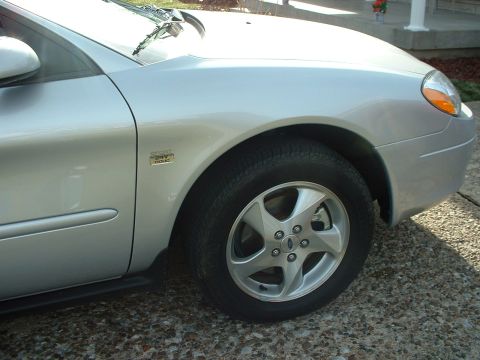2002 Ford Taurus - A silver 2002 Ford Taurus is shown from the front quarter angle, highlighting its wheel and fender.