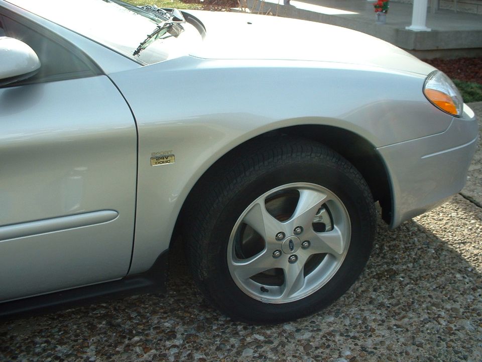 Silver Ford Taurus front fender with Sport 24V DOHC badge and alloy wheel