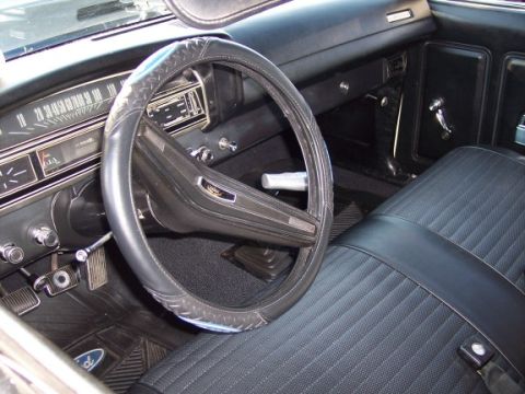 1972 Ford Ranchero - The interior of a 1972 Ford Ranchero shows its black quilted seats, dashboard, and steering wheel.