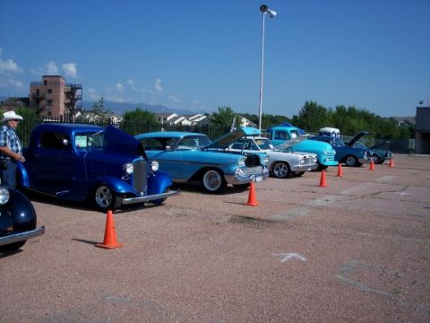 1972 Ford Ranchero - Several classic cars are lined up on a paved lot under a clear blue sky.