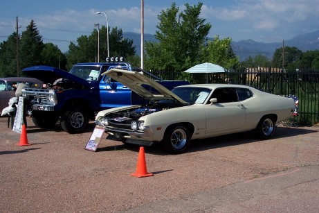 1972 Ford Ranchero - A tan 1970s coupe is parked next to a blue truck, both with hoods open at an outdoor event.