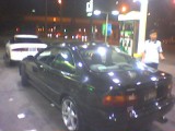 1993 Ford Probe - Two cars are seen at a gas station at night, with one car being refueled.