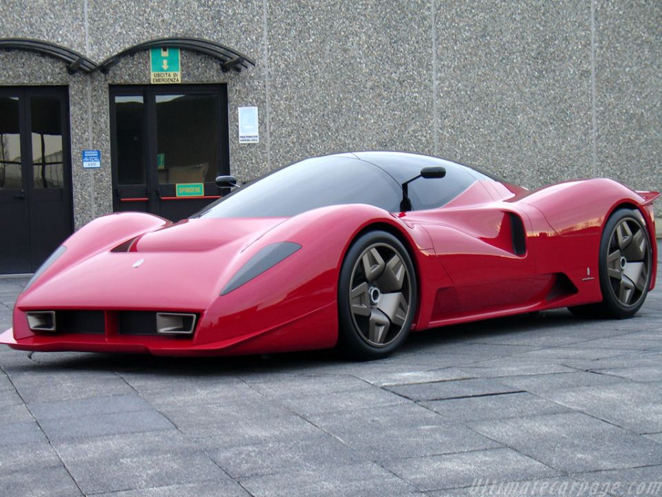 Red mid-engine supercar parked outside a building, front three-quarter view