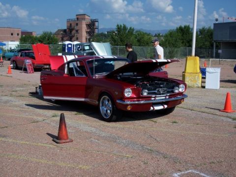 1972 Ford Ranchero - A red 1965 Ford Mustang coupe is displayed with its hood open, the engine bay and white racing stripes.