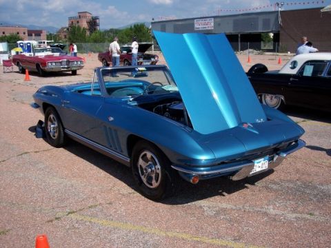 1972 Ford Ranchero - A blue convertible is parked with its hood up, showing the engine bay. Other vehicles are visible in the background.