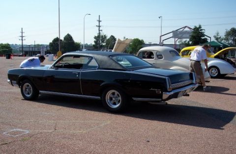 1972 Ford Ranchero - A black 1967 Mercury Cougar is parked at an outdoor car show with other vehicles visible.