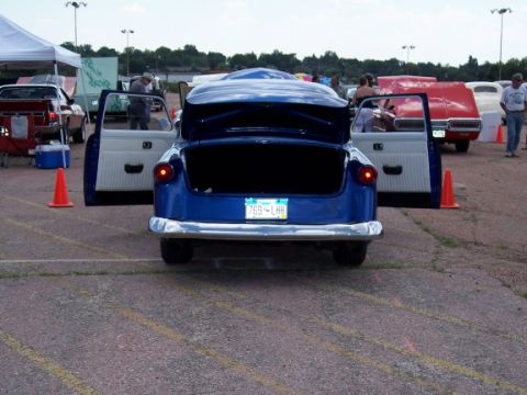 1972 Ford Ranchero - A blue 1950s car is displayed with its doors and trunk open, showing the interior and cargo space.