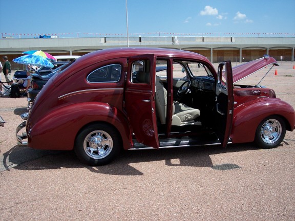 maroon sedan with doors open and hood up, parked outside