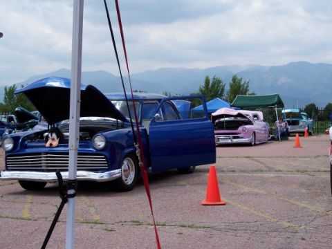 1972 Ford Ranchero - Multiple custom cars displayed outdoors with mountains in the background.