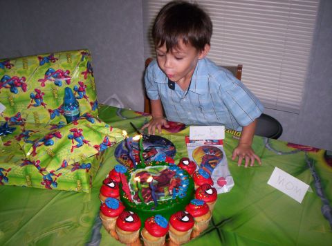 1986 Ford Bronco - A young boy celebrates his birthday by blowing out candles on a Spider-Man themed cake surrounded by cupcakes.