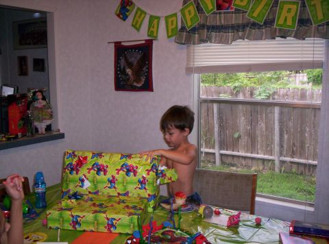 1986 Ford Bronco - A young boy unwraps a birthday gift while a 'Happy Birthday' banner hangs above.
