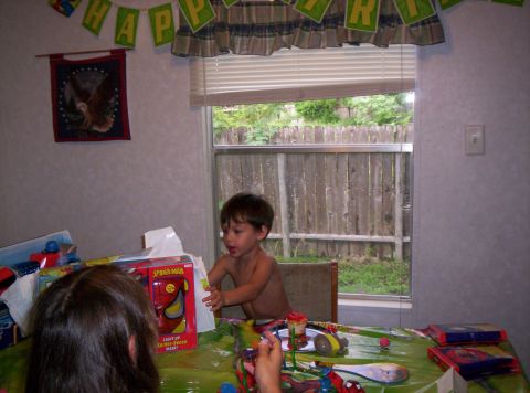 1986 Ford Bronco - A birthday party scene with a young child opening gifts, including Spider-Man toys, under a "Happy Birthday" banner.