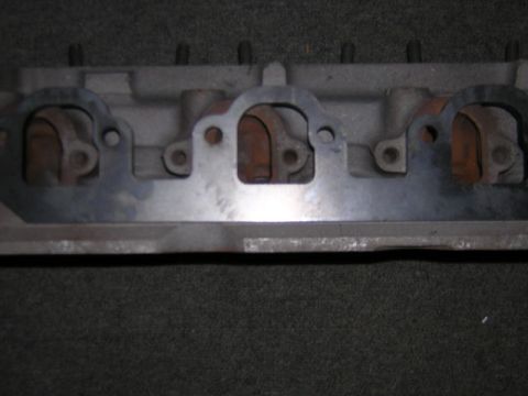 1979 Ford Bronco - Close-up view of exhaust manifold header flanges, showing gasket material and mounting holes.