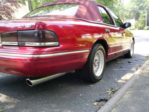 1995 Ford Crown Victoria - Rear view of a red 1995 Ford Crown Victoria sedan a maroon vinyl top and chrome trim.