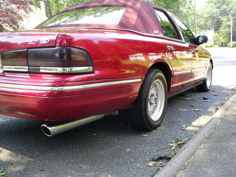 Red sedan's rear quarter panel and vinyl top. 1995 Ford Crown Victoria