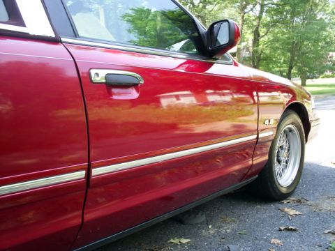 1995 Ford Crown Victoria - Side view of a red 1995 Ford Crown Victoria, highlighting the door and fender details.