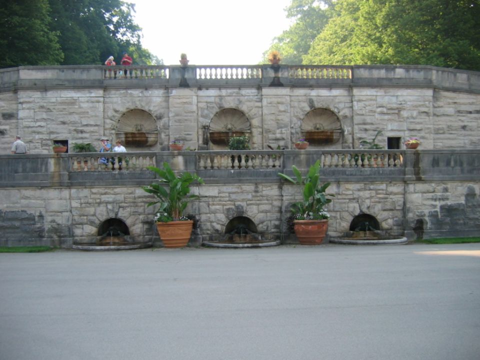 Stone garden terrace with fountains, balustrades, and potted plants