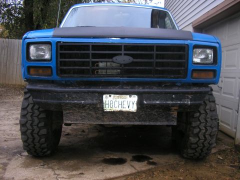 1983 Ford Bronco - This lifted 1983 Ford Bronco presents a commanding front-facing view, its tires and classic grille design.